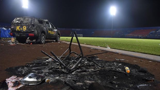 Sebuah mobil polisi berada di pinggir lapangan pascakerusuhan di Stadion Kanjuruhan, Malang, Jawa Timur, Minggu (2/10/2022). Kerusuhan yang terjadi di stadion tersebut menyebabkan 13 unit mobil rusak, 10 unit diantaranya mobil polisi dan tiga unit mobil pribadi. ANTARA FOTO/Zabur Karuru/nym.