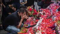 Pemain dan ofisial Arema FC berkumpul untuk berdoa di taburan bunga di luar Stadion Kanjuruhan, Malang, Jawa Timur, Senin (3/9/2022). (Juni Kriswanto/AFP/Getty Images)  