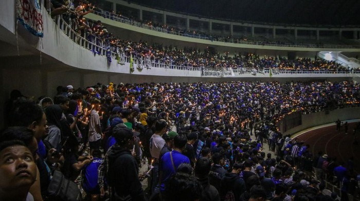 Nyala Lilin dari Semarang untuk Korban Tragedi Kanjuruhan Football supporters gather and pray as a tribute to the victims of the riots in a soccer match at the Jatidiri Stadium in Semarang, Central Java Province, Indonesia on October 2, 2022. According to government officials, at least 174 people including police officers were killed mostly in stampedes after riots following a soccer match between Persebaya Surabaya and Arema Malang at Kanjuruhan Stadium in Malang, Indonesia on October 1, 2022. (Photo by WF Sihardian/NurPhoto via Getty Images)