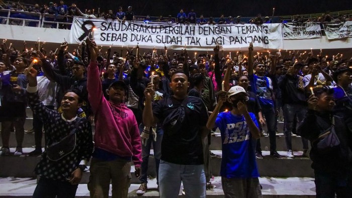 Nyala Lilin dari Semarang untuk Korban Tragedi Kanjuruhan Football supporters gather and pray as a tribute to the victims of the riots in a soccer match at the Jatidiri Stadium in Semarang, Central Java Province, Indonesia on October 2, 2022. According to government officials, at least 174 people including police officers were killed mostly in stampedes after riots following a soccer match between Persebaya Surabaya and Arema Malang at Kanjuruhan Stadium in Malang, Indonesia on October 1, 2022. (Photo by WF Sihardian/NurPhoto via Getty Images)