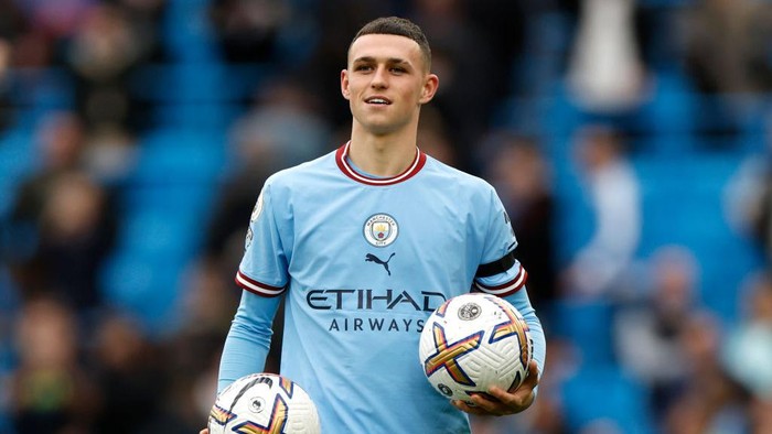 MANCHESTER, ENGLAND - OCTOBER 02: Phil Foden of Manchester City hands a match ball to team mate Erling Haaland after both scoring a hat trick during the Premier League match between Manchester City and Manchester United at Etihad Stadium on October 02, 2022 in Manchester, England. (Photo by Lynne Cameron - Manchester City/Manchester City FC via Getty Images)