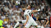 Karim Benzema (kiri) berebut bola dengan bek Osasuna Unai Garcia. La Liga Spanyol menggelar mengheningkan cipta selama satu menit pada seluruh pertandingan di pekan ketujuh. (Javier Soriano/AFP/Getty Images)