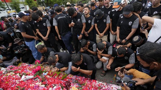 Players and officials of the soccer club Arema FC pray outside the Kanjuruhan Stadium where many fans lost their lives in a stampede Saturday night in Malang, Indonesia, Monday, Oct. 3, 2022. Police firing tear gas at Saturday night's match between host Arema FC of East Java's Malang city and Persebaya Surabaya in an attempt to stop violence triggered a disastrous crush of fans making a panicked, chaotic run for the exits, leaving a large number of people dead, most of them trampled upon or suffocated. (AP Photo/Achmad Ibrahim)