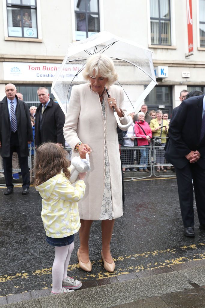 OMAGH, UNITED KINGDOM - JUNE 13:  Camilla, Duchess of Cornwall receives a toy for Prince Louis from Matilda Callahan of Dromore, during a walk about in Omagh town centre on June 13, 2018 in Omagh, Northern Ireland. The Prince of Wales and Duchess of Cornwall are paying a four day visit to Northern Ireland and the Republic of Ireland.  (Photo by Niall Carson - Pool/Getty Images)