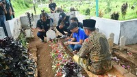 Para pemain Arema FC mengunjungi makam korban tragedi Kanjuruhan di Gondanglegi, Kabupaten Malang, Jawa Timur, Senin (3/10/2022). Putra pengasuh pondok pesantren tersebut, Syahrulloh bin Abdul Jalil menjadi salah satu korban tewas pada Tragedi Kanjuruhan. (Putri/AFP/Getty Images)  