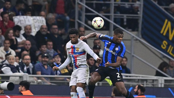 MILAN, ITALY - OCTOBER 04:  Denzel Dumfries of FC Internazionale competes for the ball with Balde of FC Barcelona during the UEFA Champions League group C match between FC Internazionale and FC Barcelona at San Siro Stadium on October 04, 2022 in Milan, Italy. (Photo by Mattia Ozbot - Inter/Inter via Getty Images)