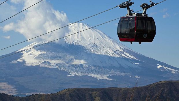 Cable car passing in front of Mount Fuji, Hakone, Japan.  If the weather is good, travelers can see a panoramic view of Mount Fuji covered in snow from a distance.  Beautiful, right?  (John S Lander/Getty Images)