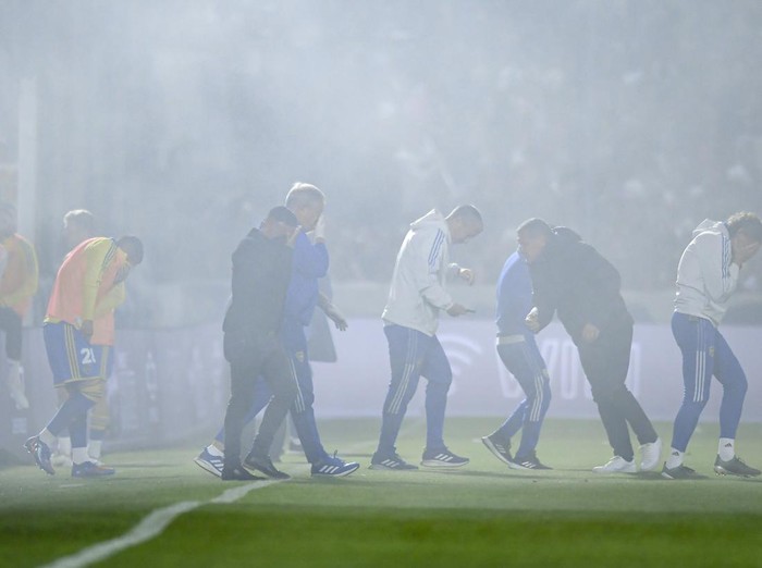 LA PLATA, ARGENTINA - OCTOBER 06: Players of Boca Juniors react after being affected by tear gas a match between Gimnasia y Esgrima La Plata and Boca Juniors as part of Liga Profesional 2022 at Juan Carmelo Zerillo Stadium on October 6, 2022 in La Plata, Argentina. The match was stopped at nine minutes of play and later cancelled amid serious incidents outside the stadium with fans and police officers who used tear gas and rubber bullets to disperse the crowd. It was reported a fan of Gimnasia died and many were injured.(Photo by Marcelo Endelli/Getty Images)