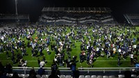 Ratusan, mungkin ribuan suporter merangsek ke lapangan untuk mencari udara segar. (Foto: Gustavo Garello/Jam Media/Getty Images)
