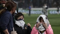 Menyedihkannya, di tribune banyak penonton perempuan dan anak-anak, yang turut menjadi korban gas air mata dari aparat. (Foto: ALEJANDRO PAGNI/AFP via Getty Images)