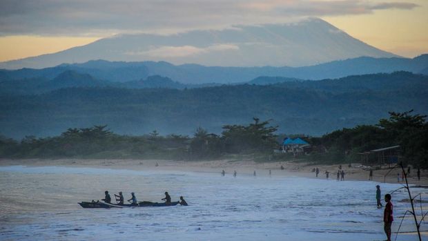Nelayan melaut dengan latar belakang Gunung Papandayan di Pantai Santolo, Pameungpeuk, Kabupaten Garut.
