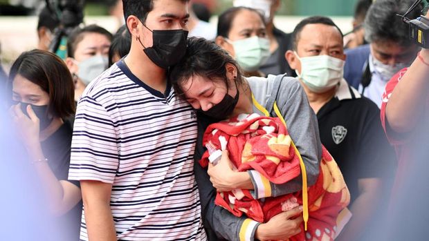 The mother of a victim holds a milk bottle and blanket as she reacts while standing outside the nursery in Na Klang in Thailand's northeastern Nong Bua Lam Phu province on October 7, 2022, the day after a former police officer killed at least 37 people in a mass shooting at the site. - Weeping, grief-stricken families gathered on October 7 outside a Thai nursery where an ex-policeman murdered nearly two dozen children in one of the kingdom's worst mass killings. (Photo by Manan VATSYAYANA / AFP)