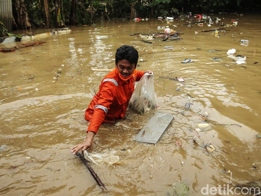 Pasukan Oranye Basah-basahan Bersihkan Sampah di Banjir Rawajati