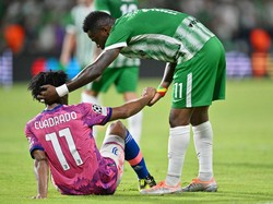 Juan Cuadrado dari Juventus berjabat tangan dengan Mavis Tchibota dari Maccabi Haifa. Maccabi juga masih berada di dasar klasemen dengan tiga poin. Klub asal Israel ini kalah selisih gol dari Juventus. Tullio Puglia/UEFA/Getty Images