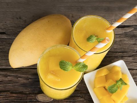 mango smoothies juice and ripe mango fruits. Yellow fruit on old wooden floor, drink in the morning to good health.