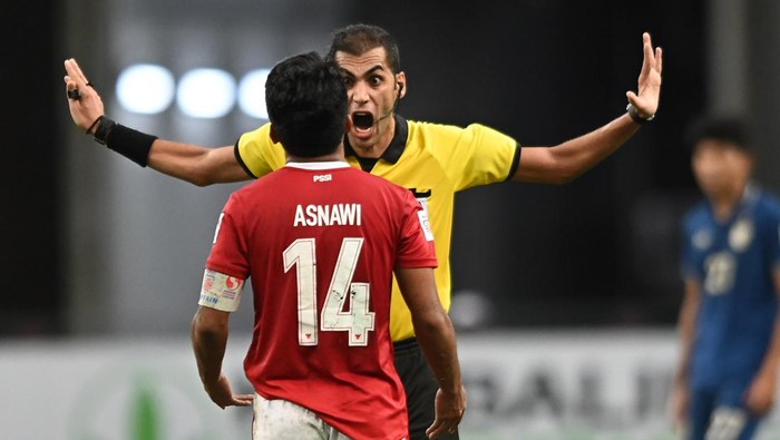 SINGAPORE, SINGAPORE - JANUARY 01: Asnawi Mangkualam #14 of Indonesia is reprimanded by referee Ahmad Faisal Mohammad Al Ali during the AFF Suzuki Cup final second leg between Thailand and Indonesia at the National Stadium on January 1, 2022 in Singapore. (Photo by Lim Weixiang/Getty Images)
