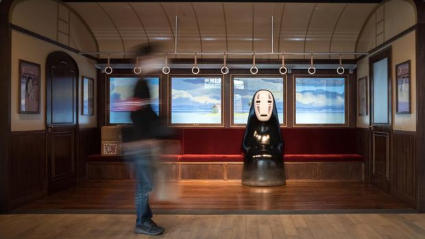 NAGAKUTE, JAPAN - OCTOBER 12: A guest attendee walks past Kaonashi or No-Face, an animation character from the film 'Spirited Away', that is copyrighted by Studio Ghibli, in the Ghibli's Grand Warehouse area during a preview for the Ghibli Park on October 12, 2022 in Nagakute, Japan. The theme park, which features Studio Ghibli animations, opens on November 1 in the Expo 2005 Aichi Commemorative Park. (Photo by Tomohiro Ohsumi/Getty Images)