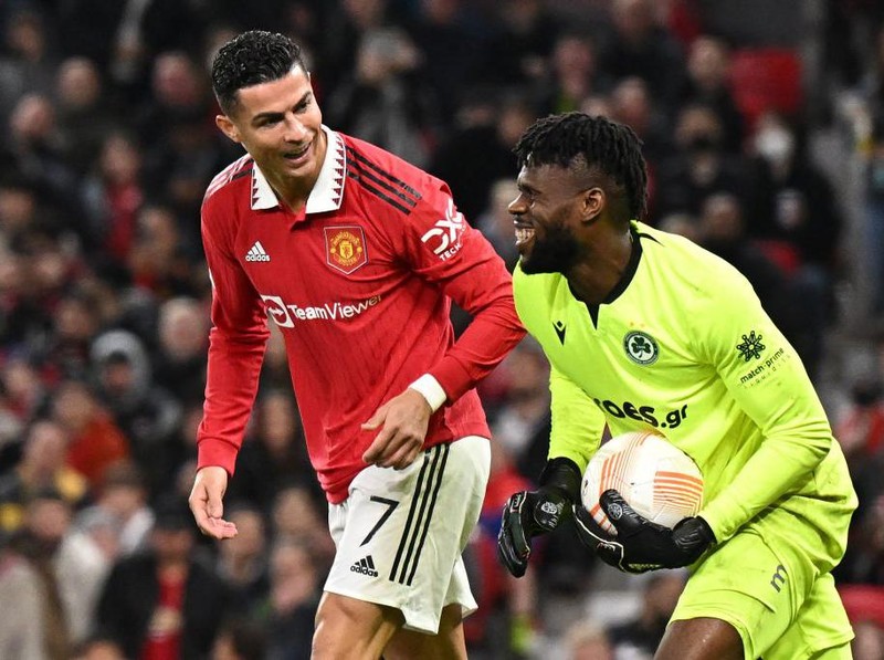 Omonia's Nigerian goalkeeper Francis Uzoho (R) shares a joke with Manchester United's Portuguese striker Cristiano Ronaldo (L) during the UEFA Europa League Group E football match between Manchester United and Omonoia Nicosia, at Old Trafford stadium, in Manchester, north-west England, on October 13, 2022. (Photo by Oli SCARFF / AFP) (Photo by OLI SCARFF/AFP via Getty Images)