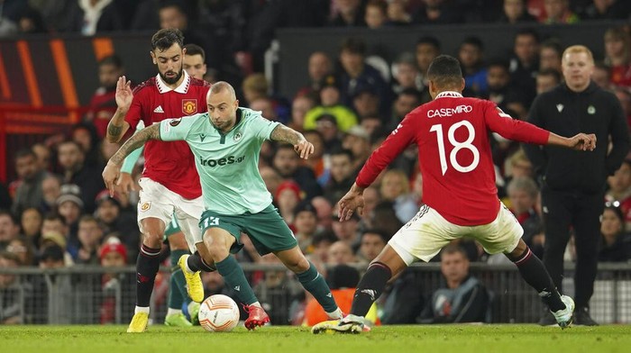 Susah Payah Manchester United Taklukkan Omonia Manchester United's Cristiano Ronaldo, left, tries to score behind Omonia's Nemanja Miletic, center as Omonia's goalkeeper Francis Uzoho, right, saves the ball during a group E Europa League soccer match between Manchester United and Omonia at Old Trafford stadium in Manchester, England, Thursday, Oct. 13, 2022. (AP Photo/Dave Thompson)