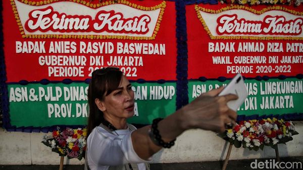 Aksi Warga Selfie dengan Karangan Bunga Perpisahan Anies