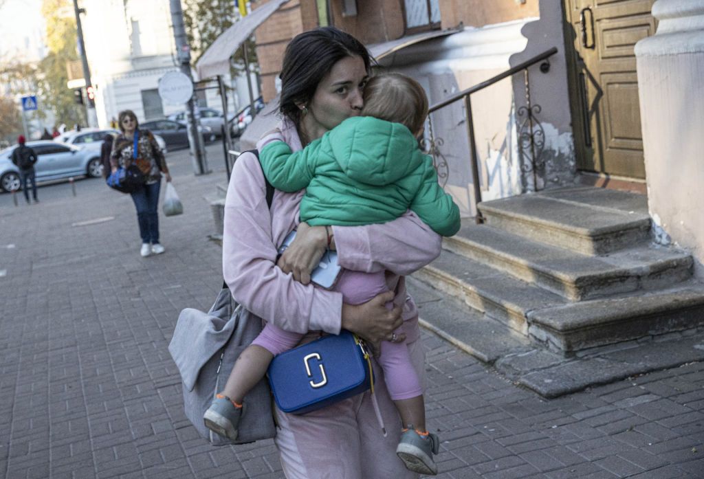 KYIV, UKRAINE - OCTOBER 17: A Ukrainian woman is seen with her child on the sidewalk after the Russian attacks in Kyiv, Ukraine on October 17, 2022. It was reported that explosions occurred in Kyiv due to the attacks carried out by the Russian forces in the early hours of the morning. (Photo by Metin Aktas/Anadolu Agency via Getty Images)