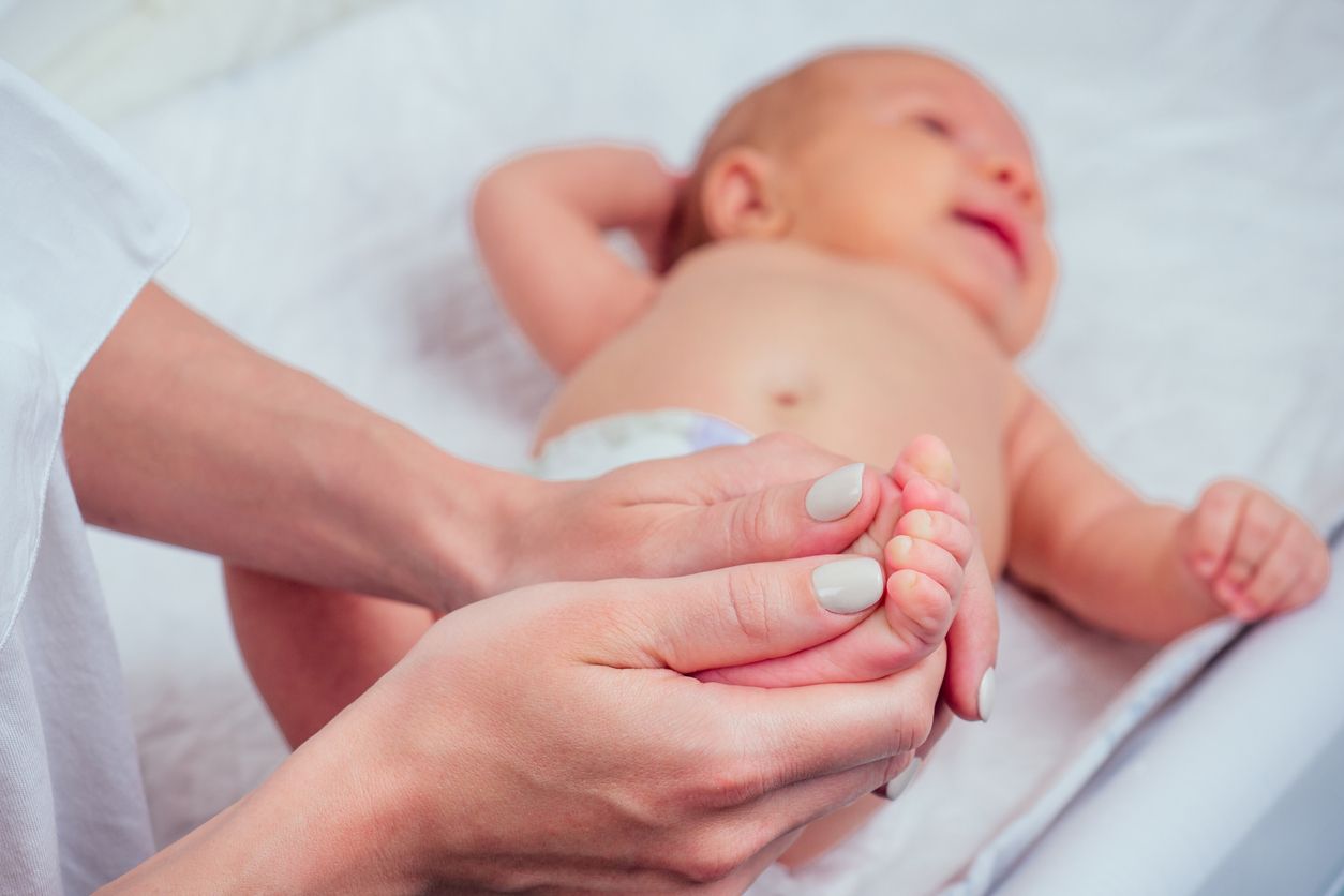 woman making foot massage to her little child close up .