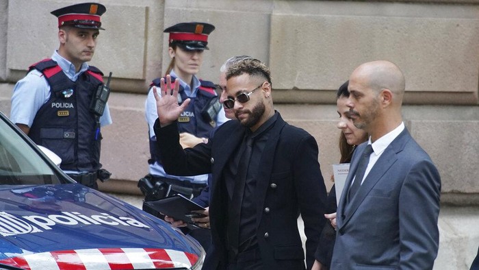 Kala Neymar Jalani Sidang Tuduhan Penipuan Transfer Former FC Barcelona player Neymar who now plays for Paris Saint-Germain waves on arrival at a court in Barcelona, Spain, Monday Oct. 17, 2022. Neymar returned to Spain Monday to face trial on fraud charges regarding his 2013 transfer from Santos to FC Barcelona. The Brazilian forward, his father, and the former executives of Barcelona and Santos are accused of hiding the true cost of his transfer with the alleged goal of cheating a private Brazilian company.(AP Photo/Joan Mateu Parra)