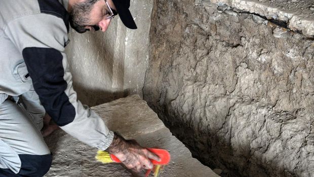 An Iraqi worker excavates a rock-carving relief recently found at the Mashki Gate, one of the monumental gates to the ancient Assyrian city of Nineveh, on the outskirts of what is today the northern Iraqi city of Mosul on October 19, 2022. (Photo by Zaid AL-OBEIDI / AFP)