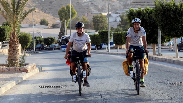 Gokil! Dua Pria Ini Gowes dari Prancis ke Qatar Demi Nonton Piala Dunia French cyclists Gabriel Martin and Mehdi Balamissa, who are cycling from France towards Doha to attend the FIFA World Cup 2022 and to support Frances football national team, ride their bicycles in Petra, during their stop in Jordan October 17, 2022. REUTERS/Alaa Al Sukhni