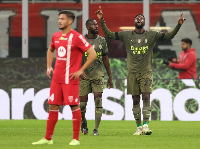 MILAN, ITALY - OCTOBER 22: Andrea Carboni of AC Monza reacts as Divock Origi of AC Milan celebrates after scoring to give the side a 3-0 lead during the Serie A match between AC Milan and AC Monza at Stadio Giuseppe Meazza on October 22, 2022 in Milan, Italy. (Photo by Jonathan Moscrop/Getty Images)
