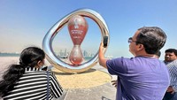 Orang-orang mengambil foto jam hitung mundur Piala Dunia 2022 Qatar di Corniche, Doha.