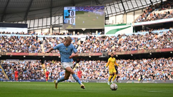 Manchester City's Norwegian striker Erling Haaland (L) scores the opening goal during the English Premier League football match between Manchester City and Brighton and Hove Albion at the Etihad Stadium in Manchester, north west England, on October 22, 2022. - RESTRICTED TO EDITORIAL USE. No use with unauthorized audio, video, data, fixture lists, club/league logos or 'live' services. Online in-match use limited to 120 images. An additional 40 images may be used in extra time. No video emulation. Social media in-match use limited to 120 images. An additional 40 images may be used in extra time. No use in betting publications, games or single club/league/player publications. (Photo by Oli SCARFF / AFP) / RESTRICTED TO EDITORIAL USE. No use with unauthorized audio, video, data, fixture lists, club/league logos or 'live' services. Online in-match use limited to 120 images. An additional 40 images may be used in extra time. No video emulation. Social media in-match use limited to 120 images. An additional 40 images may be used in extra time. No use in betting publications, games or single club/league/player publications. / RESTRICTED TO EDITORIAL USE. No use with unauthorized audio, video, data, fixture lists, club/league logos or 'live' services. Online in-match use limited to 120 images. An additional 40 images may be used in extra time. No video emulation. Social media in-match use limited to 120 images. An additional 40 images may be used in extra time. No use in betting publications, games or single club/league/player publications. (Photo by OLI SCARFF/AFP via Getty Images)