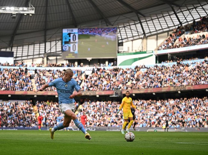 Manchester City's Norwegian striker Erling Haaland (L) scores the opening goal during the English Premier League football match between Manchester City and Brighton and Hove Albion at the Etihad Stadium in Manchester, north west England, on October 22, 2022. - RESTRICTED TO EDITORIAL USE. No use with unauthorized audio, video, data, fixture lists, club/league logos or 'live' services. Online in-match use limited to 120 images. An additional 40 images may be used in extra time. No video emulation. Social media in-match use limited to 120 images. An additional 40 images may be used in extra time. No use in betting publications, games or single club/league/player publications. (Photo by Oli SCARFF / AFP) / RESTRICTED TO EDITORIAL USE. No use with unauthorized audio, video, data, fixture lists, club/league logos or 'live' services. Online in-match use limited to 120 images. An additional 40 images may be used in extra time. No video emulation. Social media in-match use limited to 120 images. An additional 40 images may be used in extra time. No use in betting publications, games or single club/league/player publications. / RESTRICTED TO EDITORIAL USE. No use with unauthorized audio, video, data, fixture lists, club/league logos or 'live' services. Online in-match use limited to 120 images. An additional 40 images may be used in extra time. No video emulation. Social media in-match use limited to 120 images. An additional 40 images may be used in extra time. No use in betting publications, games or single club/league/player publications. (Photo by OLI SCARFF/AFP via Getty Images)