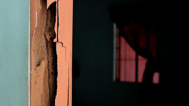 Selective focus of door wooden beam frame damaged by termites with black copy space. Abandoned deteriorating house concept.