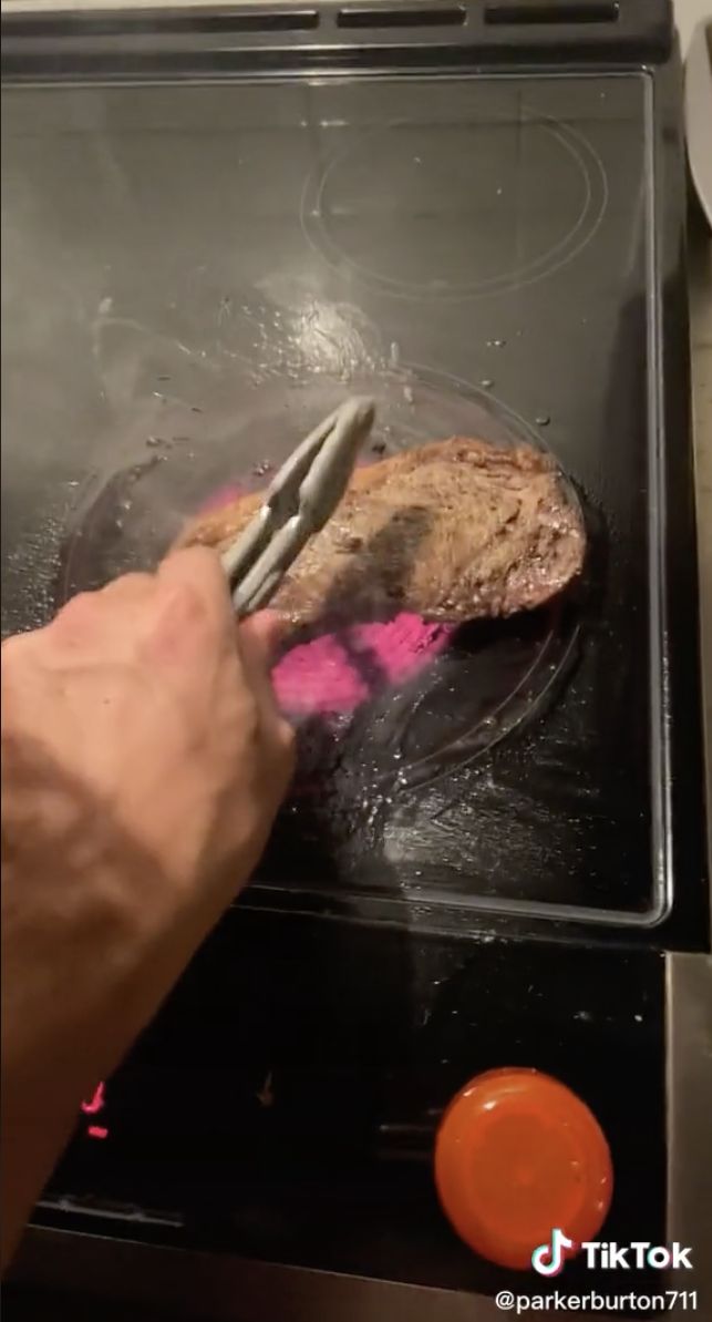 Orang masak steak di kompor listrik