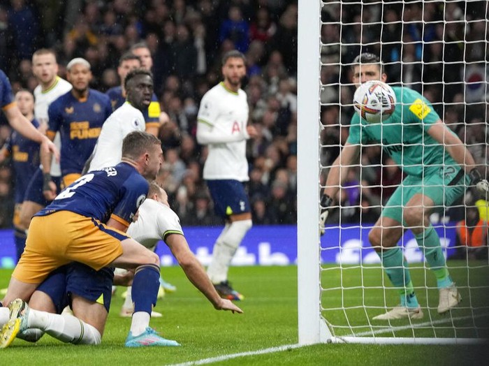 Newcastle's goalkeeper Nick Pope, left, punches the ball away under pressure from Tottenham's Davinson Sanchez, right, during the English Premier League soccer match between Tottenham Hotspur and Newcastle United at the Tottenham Hotspur Stadium in London, England, Sunday, Oct. 23, 2022. (AP Photo/Frank Augstein)