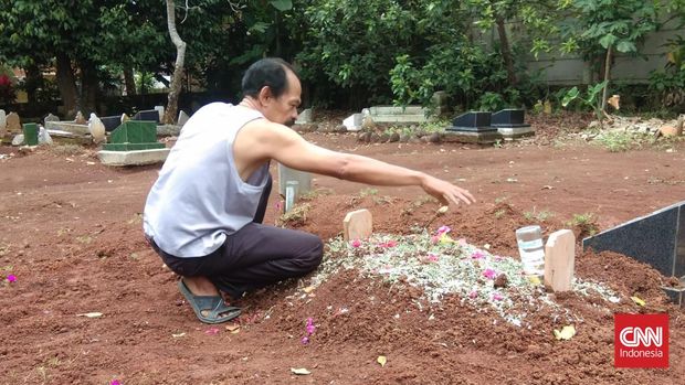 Pihak keluarga di depan makam bayi usia 11 bulan, MAF, yang meninggal karena gagal ginjal akut, Bandar Lampung, Sabtu (22/10). MAF meninggal Sabtu malam di RSUAM Bandar Lampung. (CNNIndonesia/Zainal)