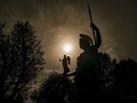 Patung dewi Minerva dilatarbelakangi oleh gerhana matahari sebagian di Bucharest, Rumania, Selasa (25/10/2022). Sebagai dampaknya, wilayah yang mengalami fenomena gerhana tersebut akan mengalami pasang purnama, yakni pasang tertinggi yang terjadi saat Matahari-Bulan-Bumi berada dalam konfigurasi satu lurus. (AP Photo/Vadim Ghirda)