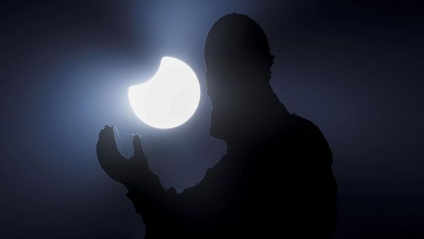 A statue on top of the Bernini's colonnade is pictured during a partial solar eclipse in St. Peter's Square at the Vatican, October 25, 2022. REUTERS/Guglielmo Mangiapane     TPX IMAGES OF THE DAY
