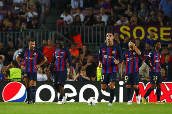 Barcelona players react after Bayerns Benjamin Pavard scores his sides third goal during the Champions League Group C soccer match between Barcelona and Bayern Munich at the Camp Nou stadium in Barcelona, Spain, Wednesday, Oct. 26, 2022. (AP Photo/Joan Monfort)