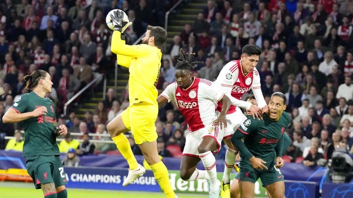 Bungkam Ajax, Liverpool Melaju ke 16 Besar Liga Champions Ajax's Jurrien Timber vies for the ball with Liverpool's Roberto Firmino and Andrew Robertson, left, during the Champions League group A soccer match between Ajax and Liverpool at the Johan Cruyff ArenA in Amsterdam, Netherlands, Wednesday, Oct. 26, 2022. (AP Photo/Peter Dejong)