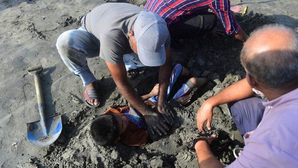 Potret Orang Tua di Pakistan Ramai Menanam Anak di Dalam Pasir