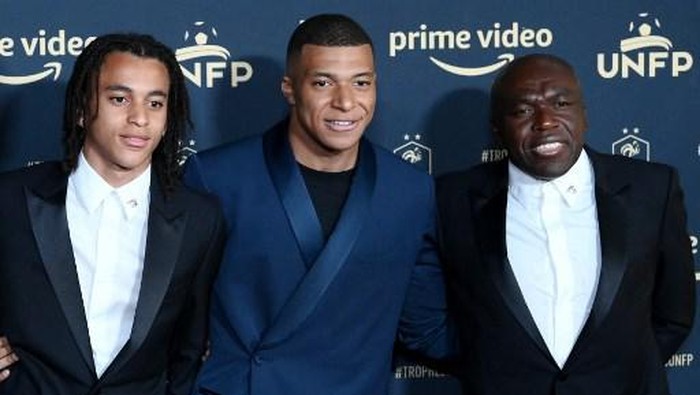Paris Saint-Germains French forward Kylian MBappe (C),  his father Wilfried Mbappe (R) and his brother Ethan (L) pose ahead of the TV show on May 15, 2022 in Paris, as part of the 30th edition of the UNFP (French National Professional Football players Union) trophy ceremony. (Photo by FRANCK FIFE / AFP)