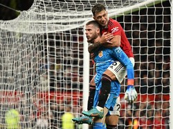Lisandro Martinez juga tahu betapa krusialnya aksi-aksi De Gea di laga ini. Foto: AFP via Getty Images/OLI SCARFF