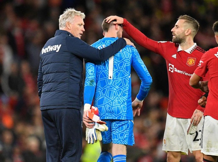 West Ham United's Scottish manager David Moyes (L) and Manchester United's English defender Luke Shaw (R) congratulate Manchester United's Spanish goalkeeper David de Gea (C) on the pitch after the English Premier League football match between Manchester United and West Ham United at Old Trafford in Manchester, north-west England, on October 30, 2022. - Man Utd won the game 1-0. - RESTRICTED TO EDITORIAL USE. No use with unauthorized audio, video, data, fixture lists, club/league logos or 'live' services. Online in-match use limited to 120 images. An additional 40 images may be used in extra time. No video emulation. Social media in-match use limited to 120 images. An additional 40 images may be used in extra time. No use in betting publications, games or single club/league/player publications. (Photo by Oli SCARFF / AFP) / RESTRICTED TO EDITORIAL USE. No use with unauthorized audio, video, data, fixture lists, club/league logos or 'live' services. Online in-match use limited to 120 images. An additional 40 images may be used in extra time. No video emulation. Social media in-match use limited to 120 images. An additional 40 images may be used in extra time. No use in betting publications, games or single club/league/player publications. / RESTRICTED TO EDITORIAL USE. No use with unauthorized audio, video, data, fixture lists, club/league logos or 'live' services. Online in-match use limited to 120 images. An additional 40 images may be used in extra time. No video emulation. Social media in-match use limited to 120 images. An additional 40 images may be used in extra time. No use in betting publications, games or single club/league/player publications. (Photo by OLI SCARFF/AFP via Getty Images)