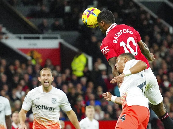 Manchester United's Marcus Rashford, top right, scores his side's opening goal during the English Premier League soccer match between Manchester United and West Ham United at Old Trafford stadium in Manchester, England, Sunday, Oct. 30, 2022. (AP Photo/Jon Super)