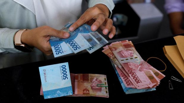 A teller counts Indonesian rupiah bank notes at a money changer in Jakarta, Indonesia, October 14, 2022. REUTERS/Willy Kurniawan