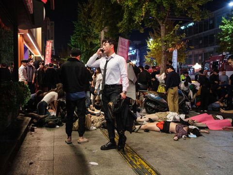 EDITORS NOTE: Graphic content / This picture taken on October 30, 2022 shows a man standing near the bodies of victims of a Halloween stampede in the district of Itaewon in Seoul. - More than 150 people have been killed in a stampede at a Halloween event in Seoul, officials said on October 30, with South Korea's president vowing a thorough investigation into one of the country's worst-ever disasters. (Photo by Albert RETIEF / AFP) (Photo by ALBERT RETIEF/AFP via Getty Images)