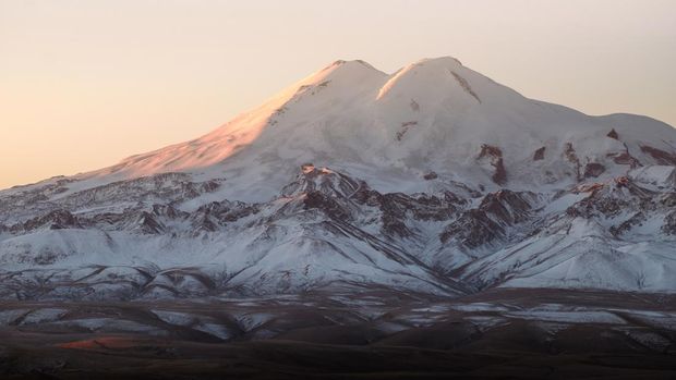 Beautiful photography of the snowy mountain Elbrus. Autumn weather, nature travel in Russia. Sunny outdoor scenics.