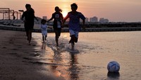 Anak-anak yang bermain bola kerap terlihat di pantai hingga taman kota. (Mohammed Dabbous/Getty Images)  